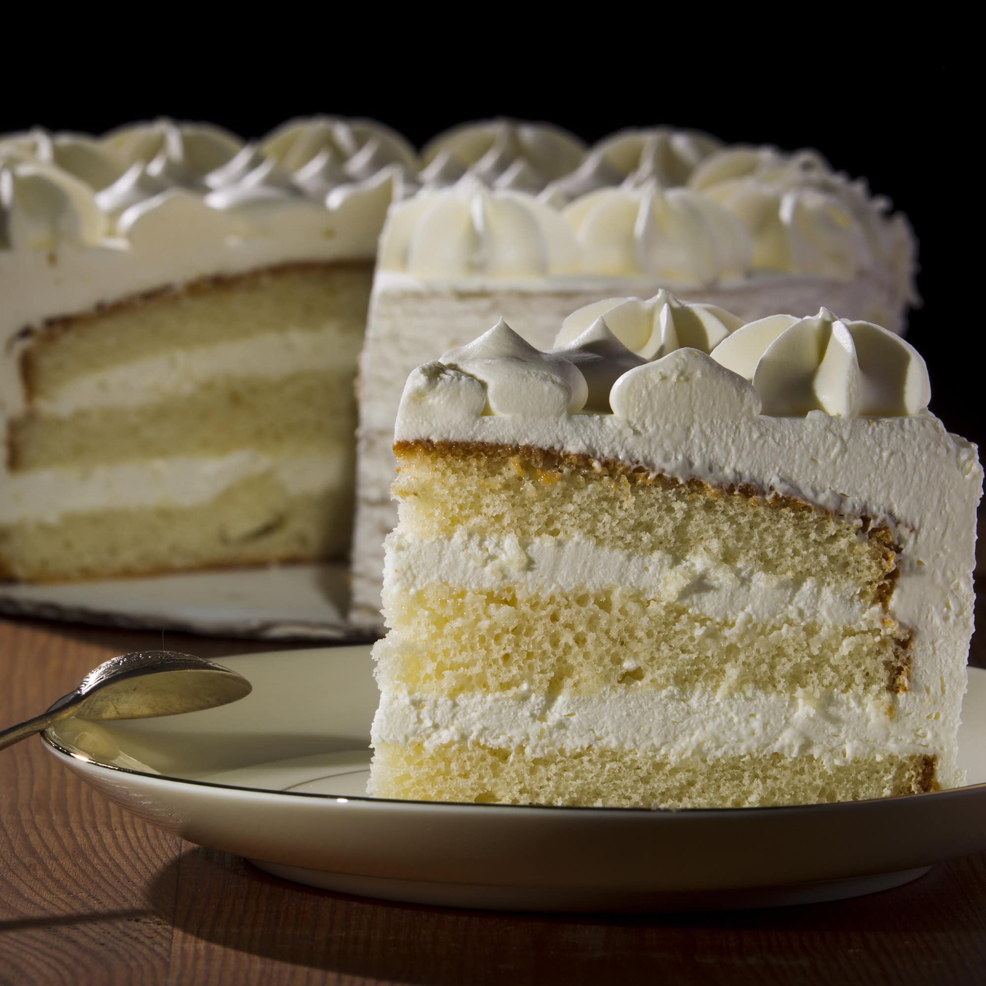 A slice of light sponge cake served with a De Luxe French cocktail.