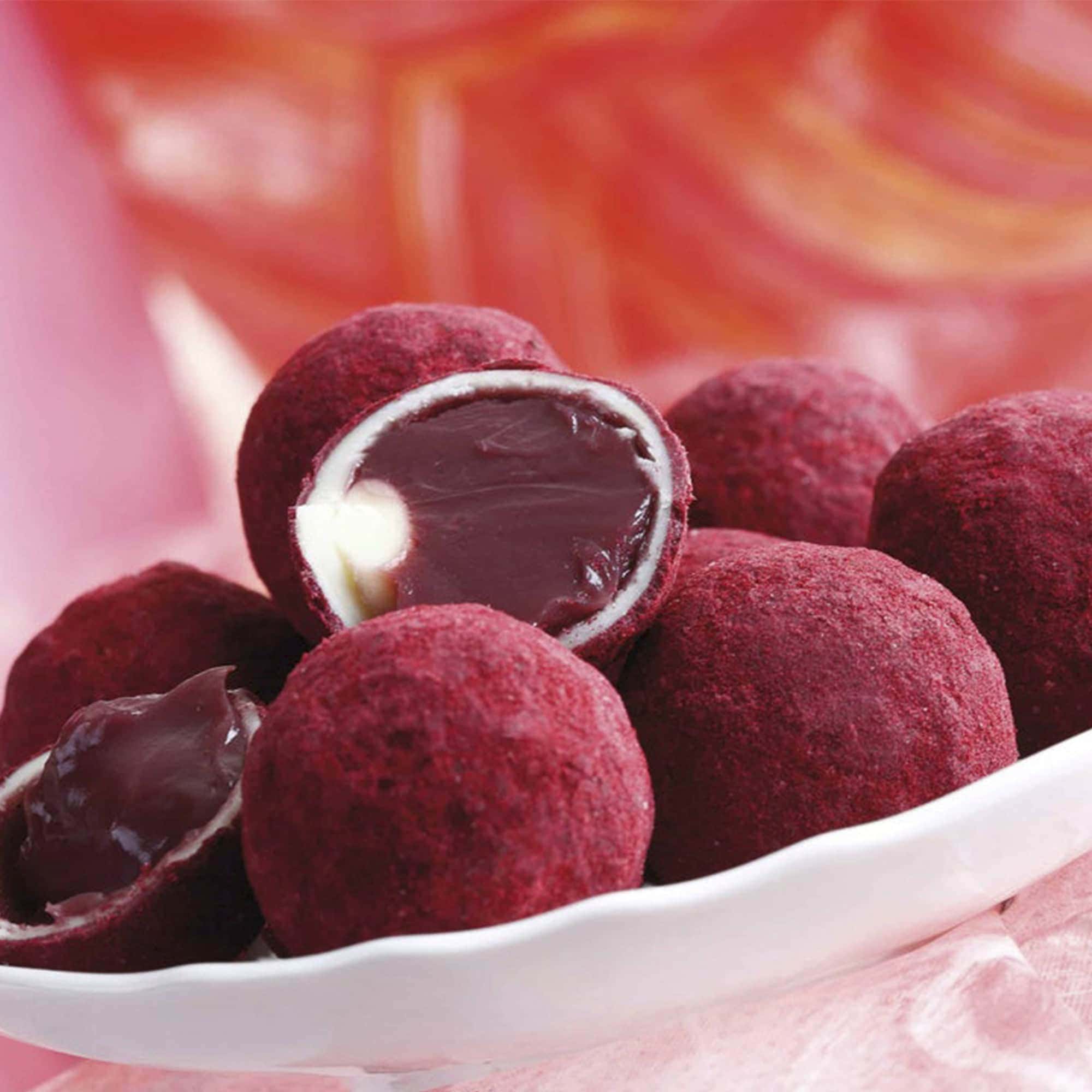 Chocolate truffles with a red coating, one cut open